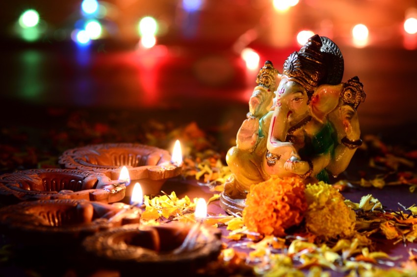 Clay diya lamps lit with Lord Ganesha during Diwali Celebration. Greetings Card Design Indian Hindu Light Festival called Diwali