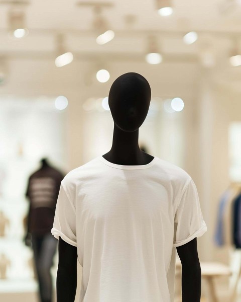 Black Mannequin Showcasing White T-Shirt in Retail Store